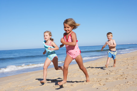 Three Children Running Along Beach